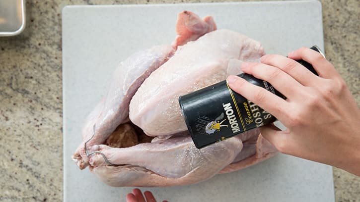 Turkey being salted for dry brine