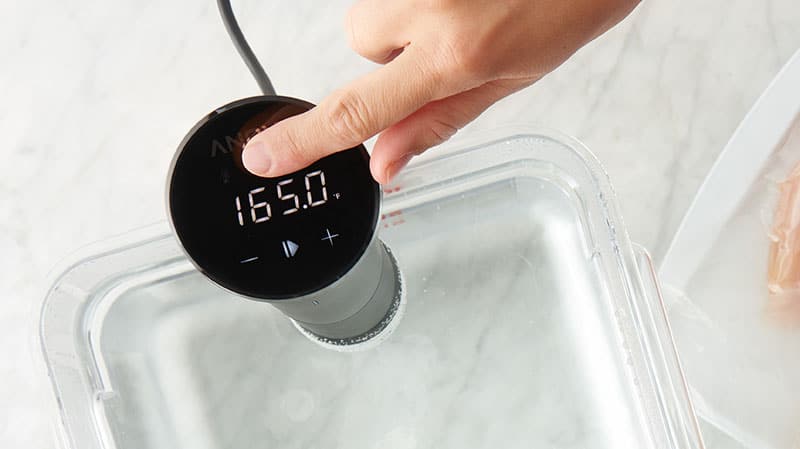 Sous vide machine in a large container with water